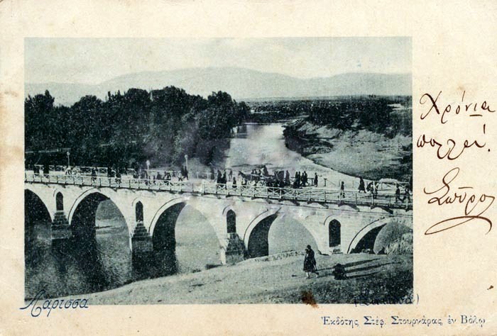 «Η γέφυρα του Πηνειού. Φωτογραφία του 1900 περίπου του φωτογράφου Στεφ. Στουρνάρα από τον Βόλο. Από τα παλαιότερα επιστολικά δελτάρια, τα οποία κυκλοφόρησαν για τη Λάρισα».